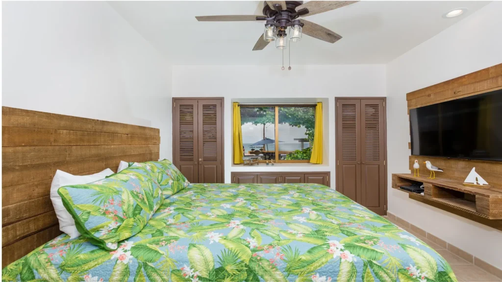 Bright king bedroom with tropical bedding and cozy window nook in beachfront condo