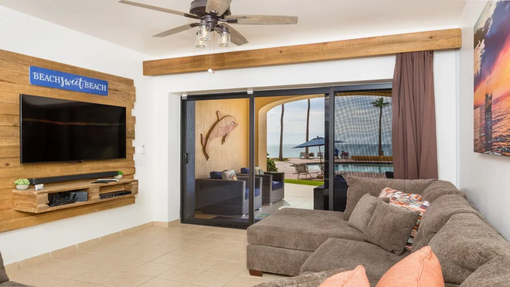 Living room with sliding doors opening to patio and pool area at beachfront condo