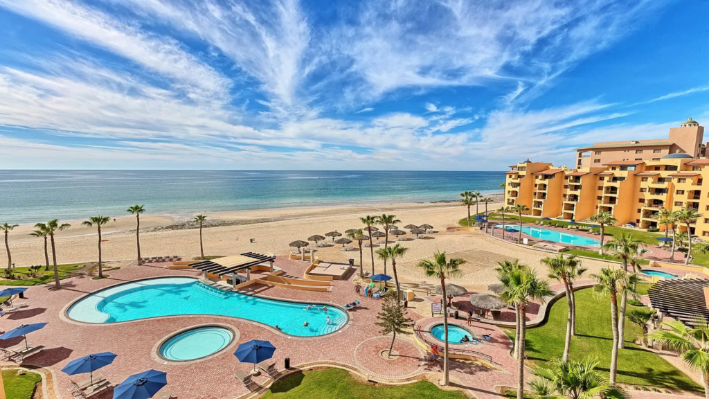 Clear sunny day view of a winding resort pool overlooking the vast blue Sea of Cortez.