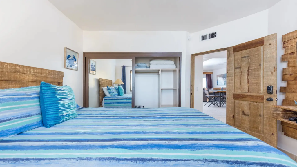 Bedroom view showing a large mirrored sliding closet and a rustic wooden door leading to the living area.