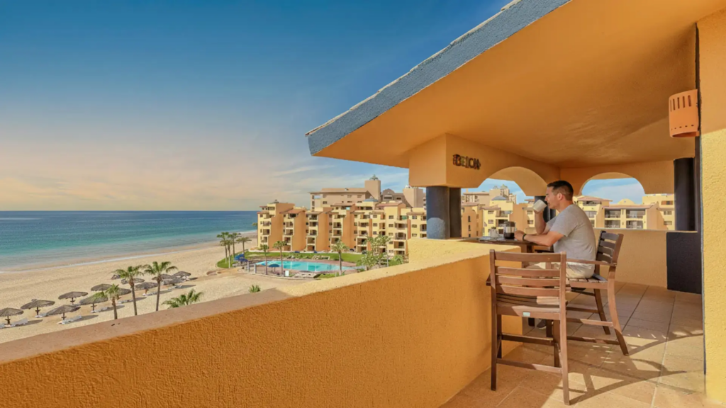 Wide-angle view of the private balcony showing the resort grounds and shoreline.