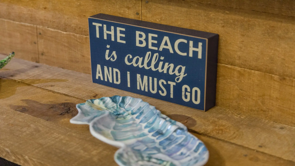 Navy decorative sign featuring coastal phrase
