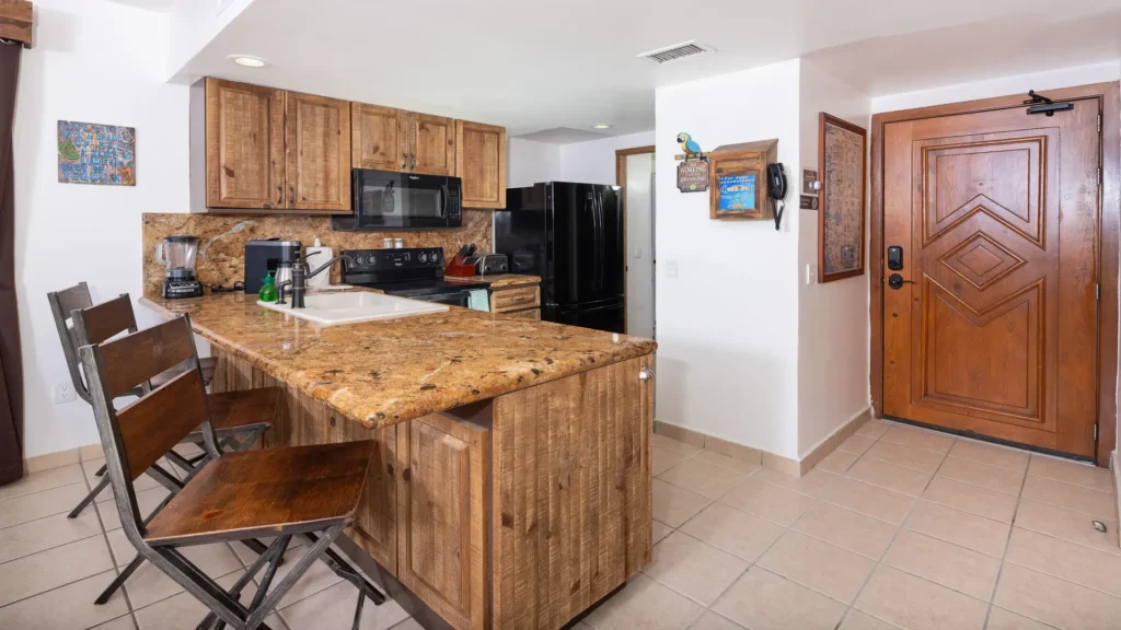Fully equipped kitchen with granite countertops and full-size appliances in the E501 2BD two-story penthouse at Princesa Sandy Beach, Rocky Point, perfect for family cooking.