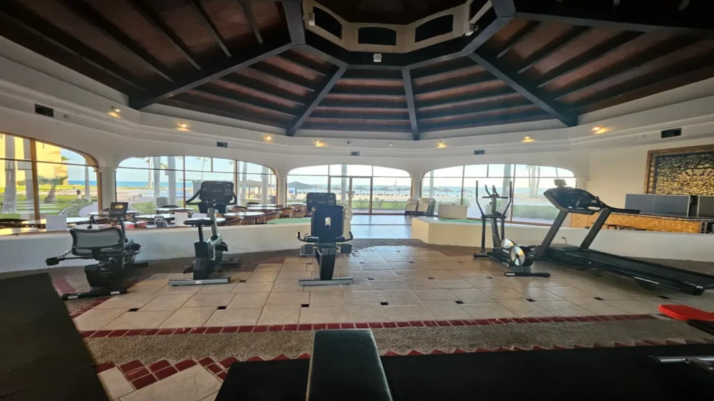 Golden views and coastal scenery from the Princesa 2BD two-story oceanfront penthouse in Rocky Point – cardio machines and open workout space in the princesa resort gym with ocean views near the e501 2bd penthouse rental.