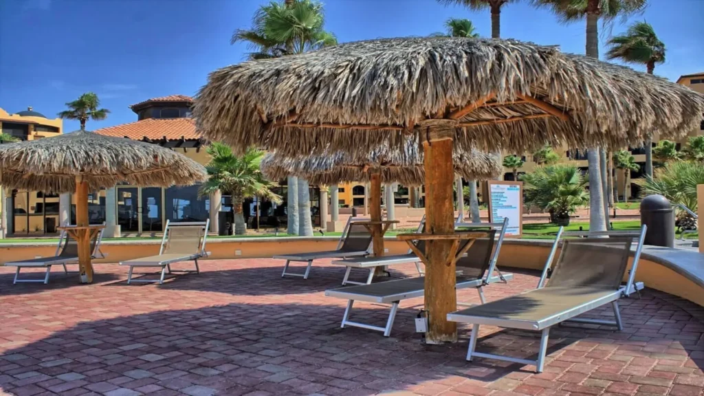The iconic beach palapas dotting the shores of Rocky Point Sandy Beach, offering a refreshing, shady retreat right near your unit, 3BD D503, for a truly relaxing day.