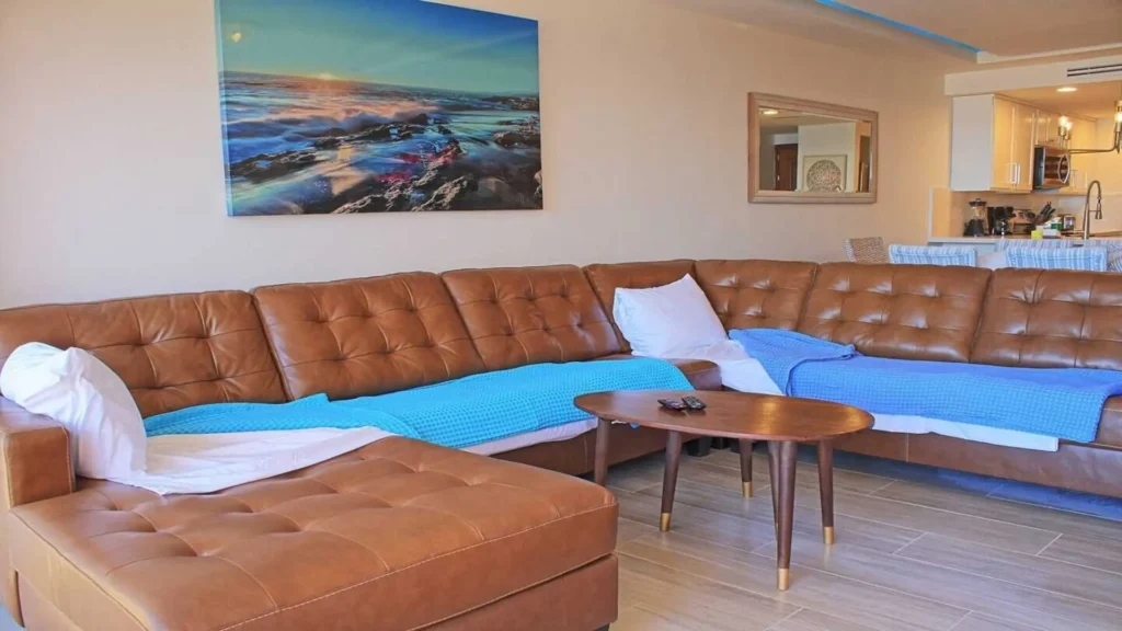 The living area of 3BD D503, featuring a comfortable, spacious sofa/couch for relaxation with views of Rocky Point Sandy Beach.