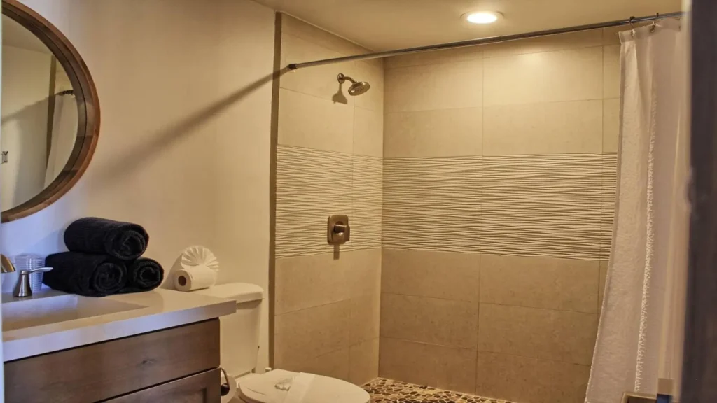 Clean, recently remodeled shower area in the 3BD D503 bathroom, featuring bright tiles and modern fixtures at Rocky Point Sandy Beach.