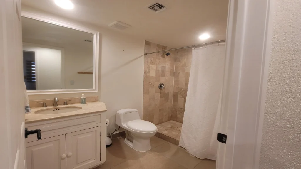 Hall/guest bathroom featuring a stand-up shower, sink, and toilet for added convenience.