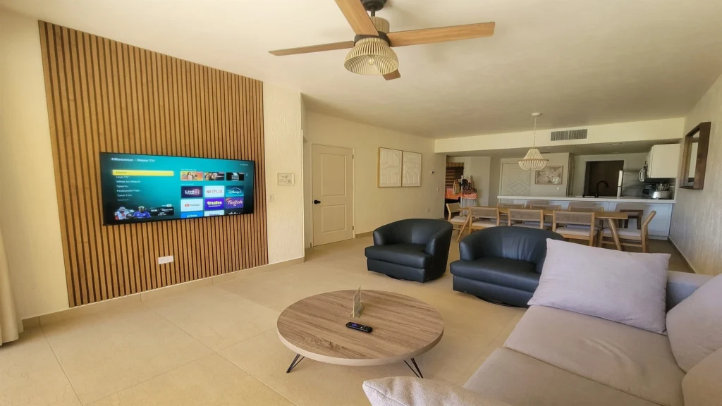 Spacious living room with queen pull out sofa, Roku TV, 2 swivel leather barrel chairs and remodeled media wall.